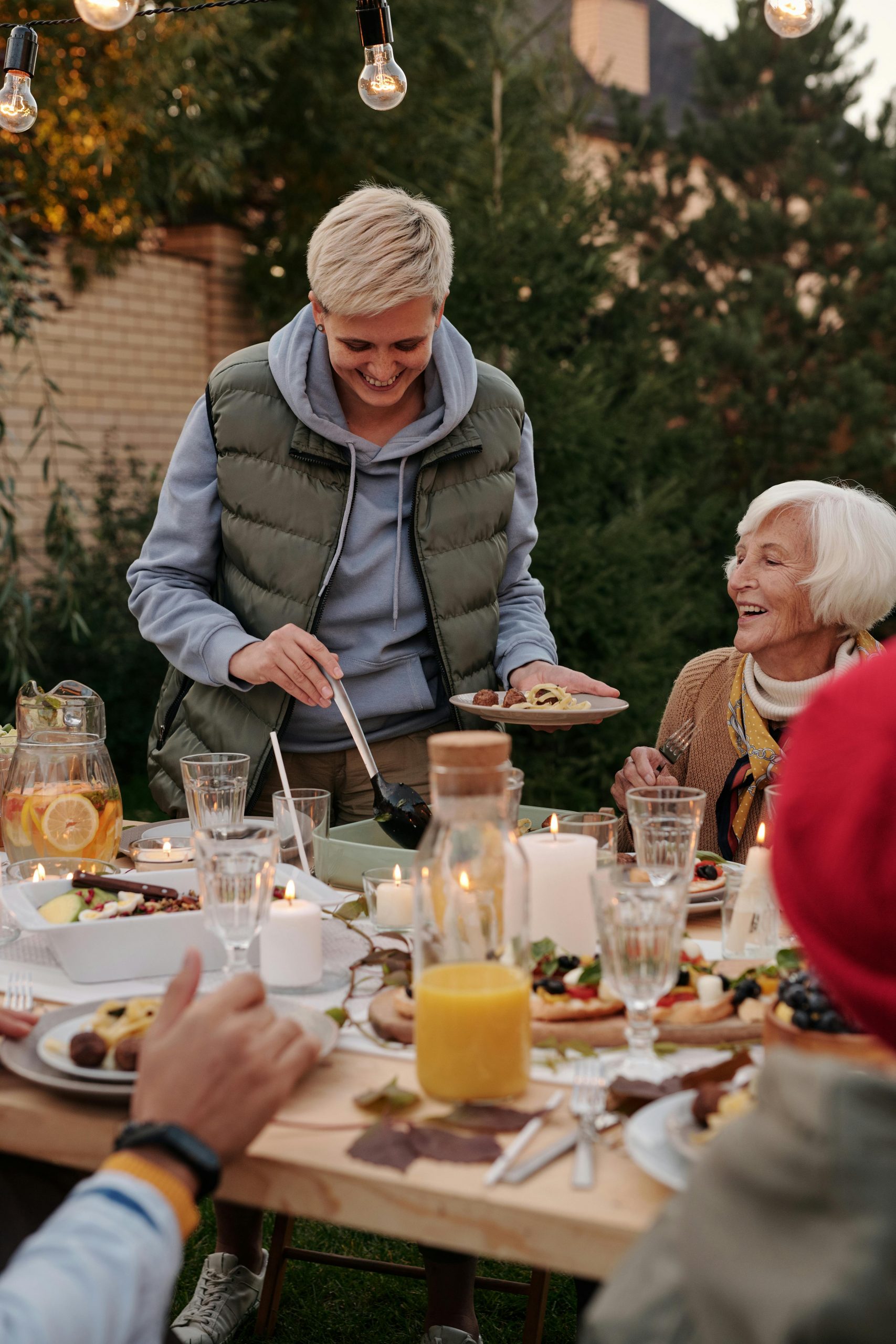 Family gathered around a Thanksgiving dinner table, sharing a meal and expressing gratitude in a warm, festive setting.